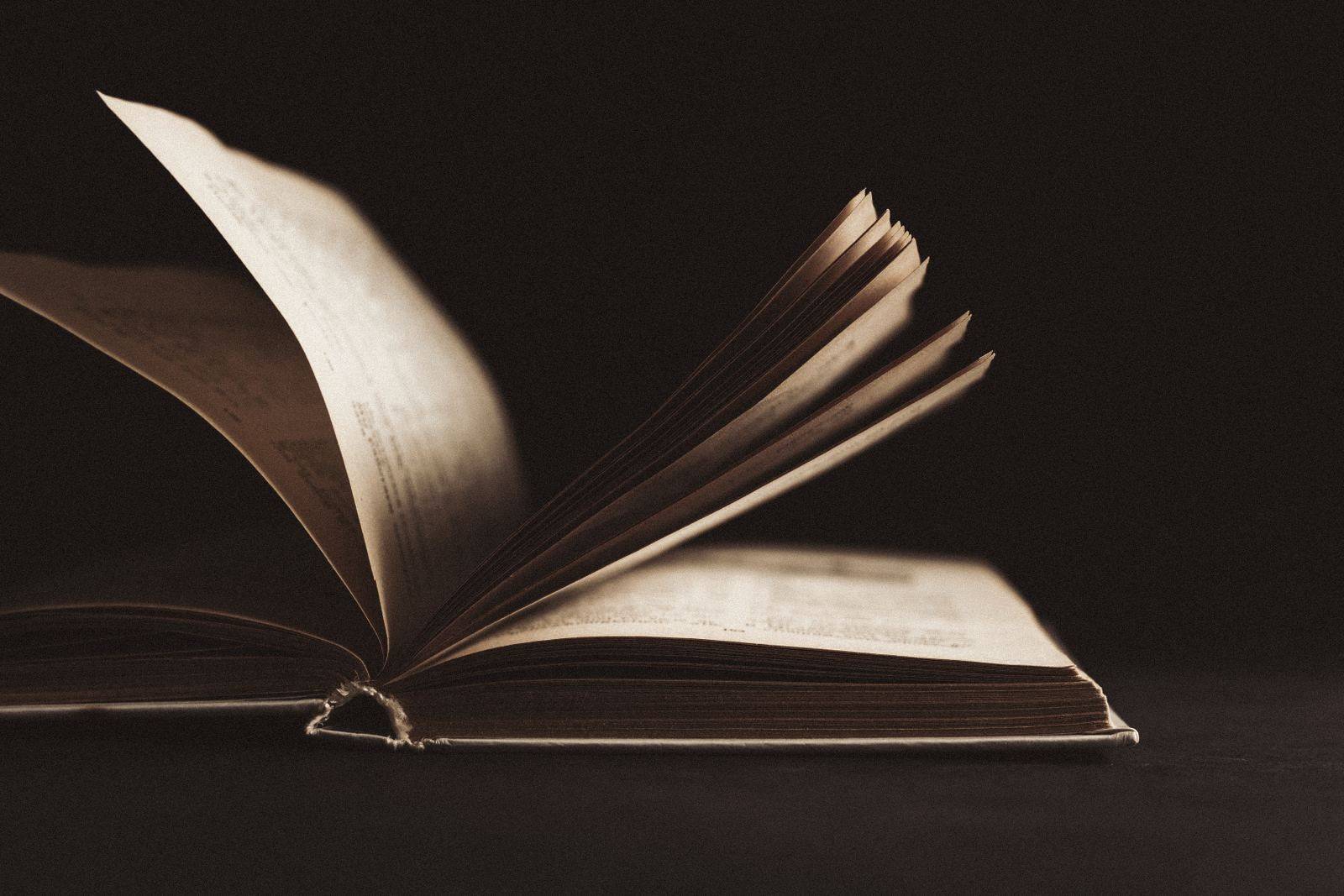 Livro aberto sobre uma mesa escura