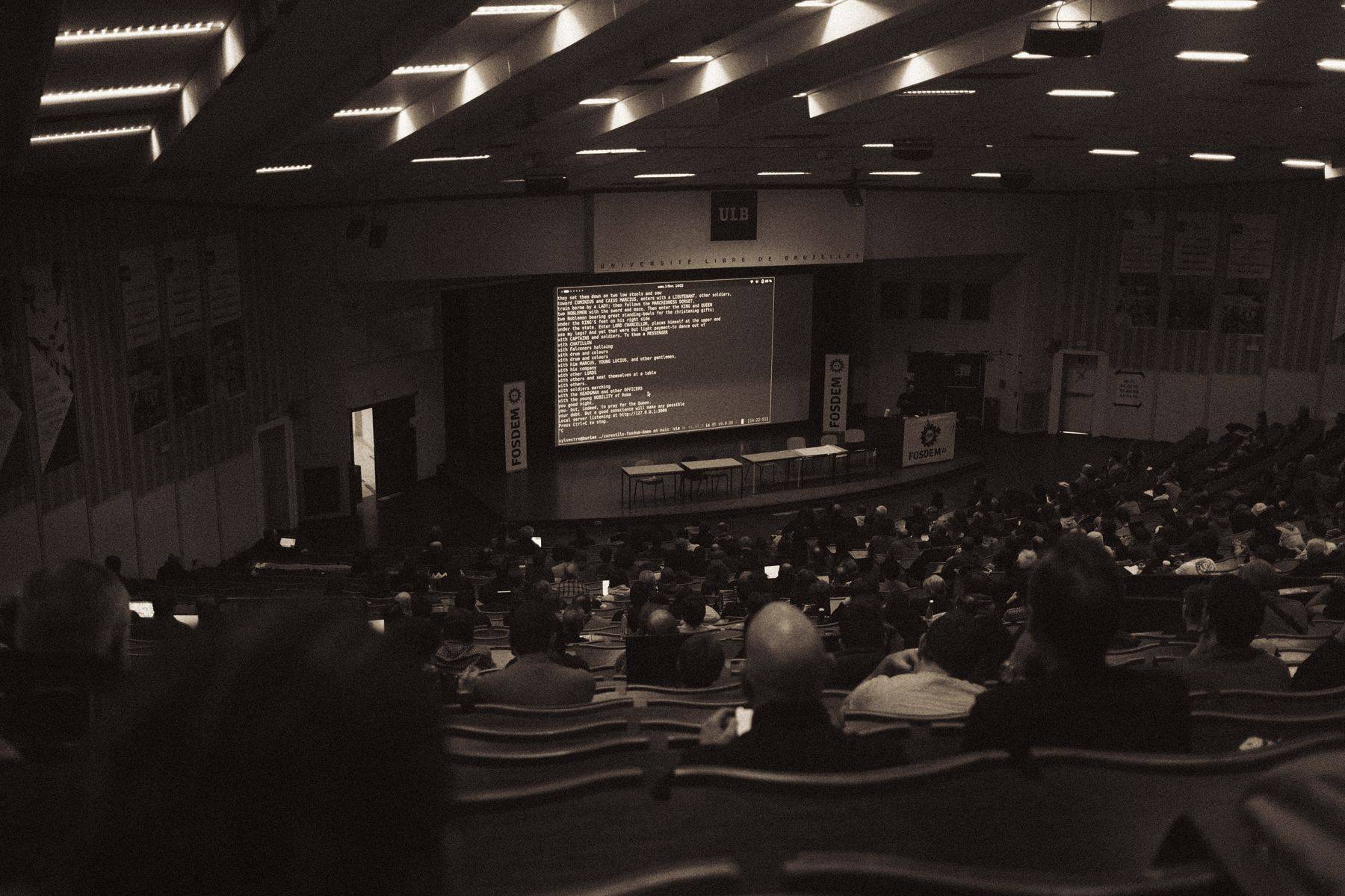 Plateia assistindo a uma palestra em auditório